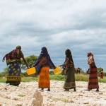 Four women in Africa collecting water.